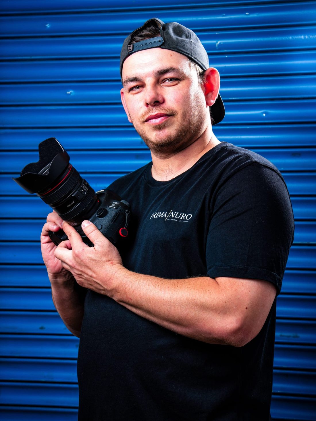 Matt Witchalls, founder and creative director of Prima Nuro, holding a Canon camera